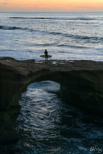 Surfer Standing Atop Arch at Sunset Cliffs, San Diego, California, photo